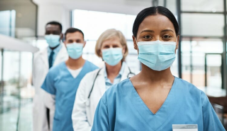 4 medical professionals wearing masks lined up