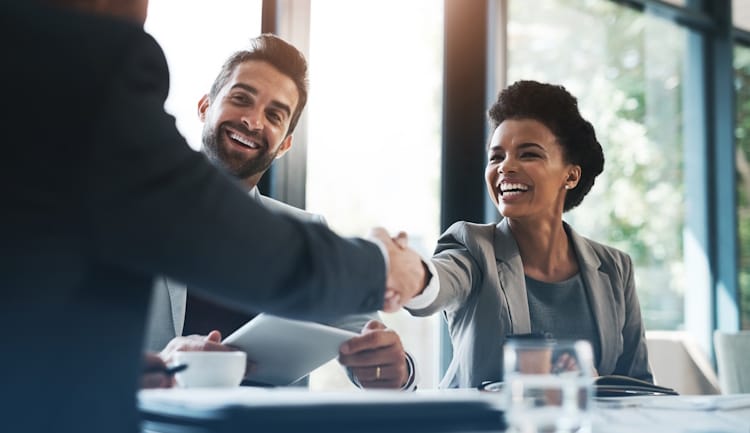 people shaking hands in business meeting