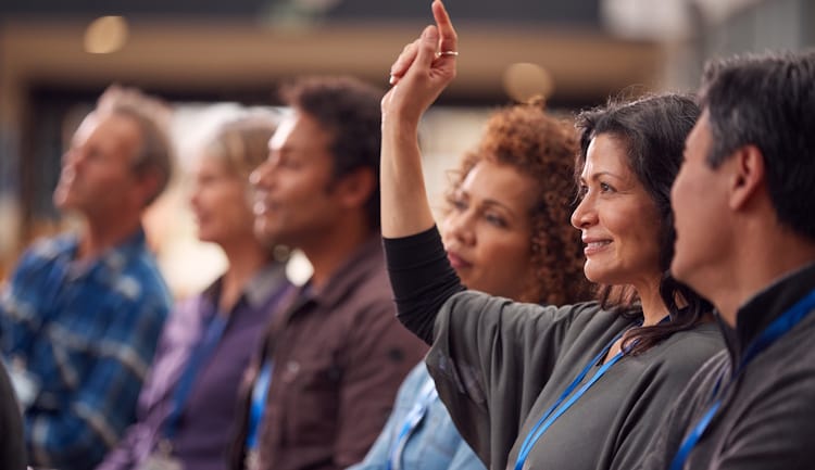 woman raising hand to ask question